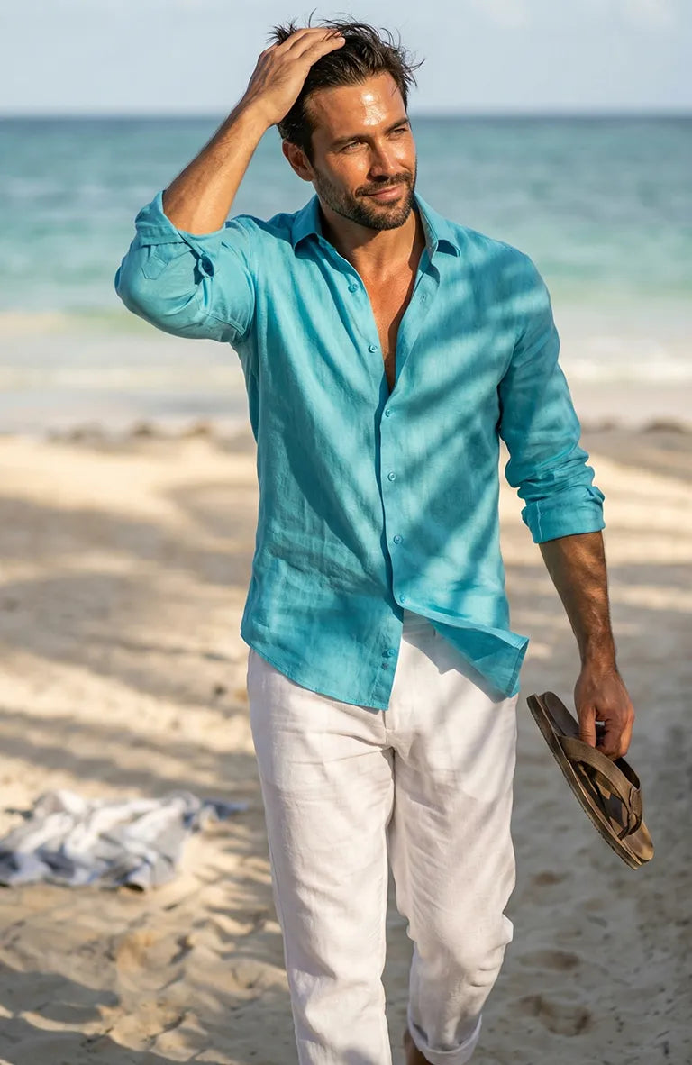 Man in a Bradford Italian Linen Shirt in Malibu and white pants standing on a beach.
